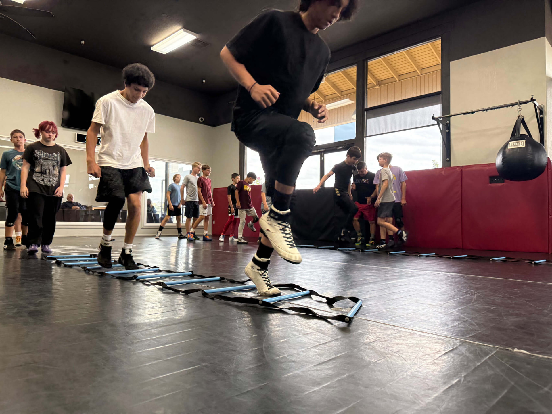 Wrestlers completing agility ladder warm-ups at MatTime