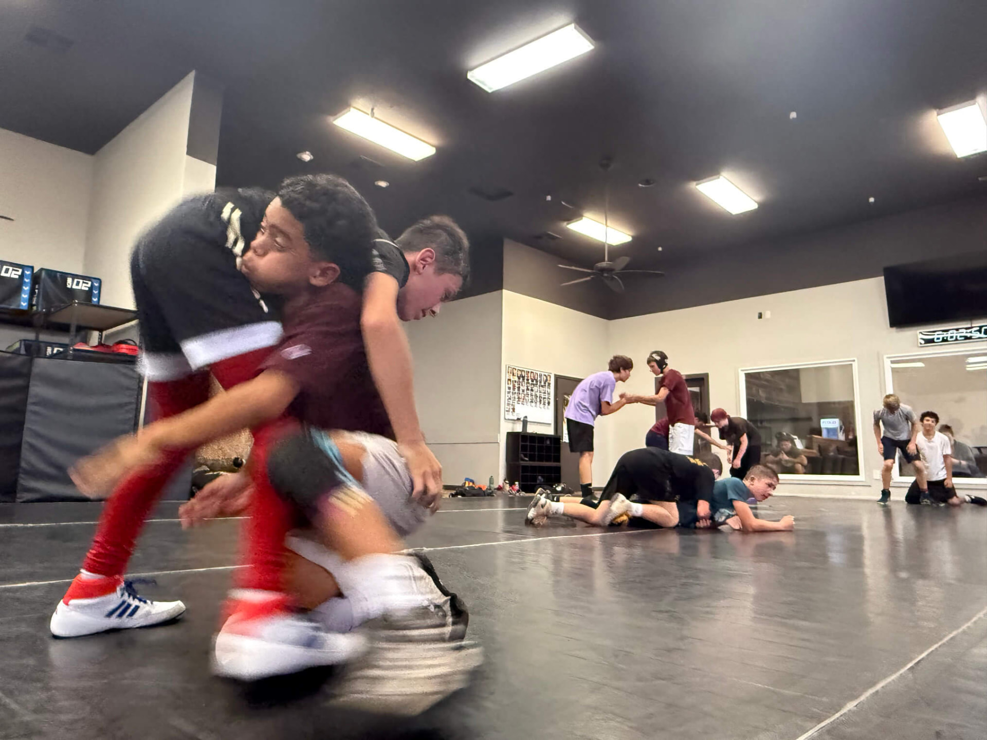 Wrestlers practicing a takedown shot at MatTime