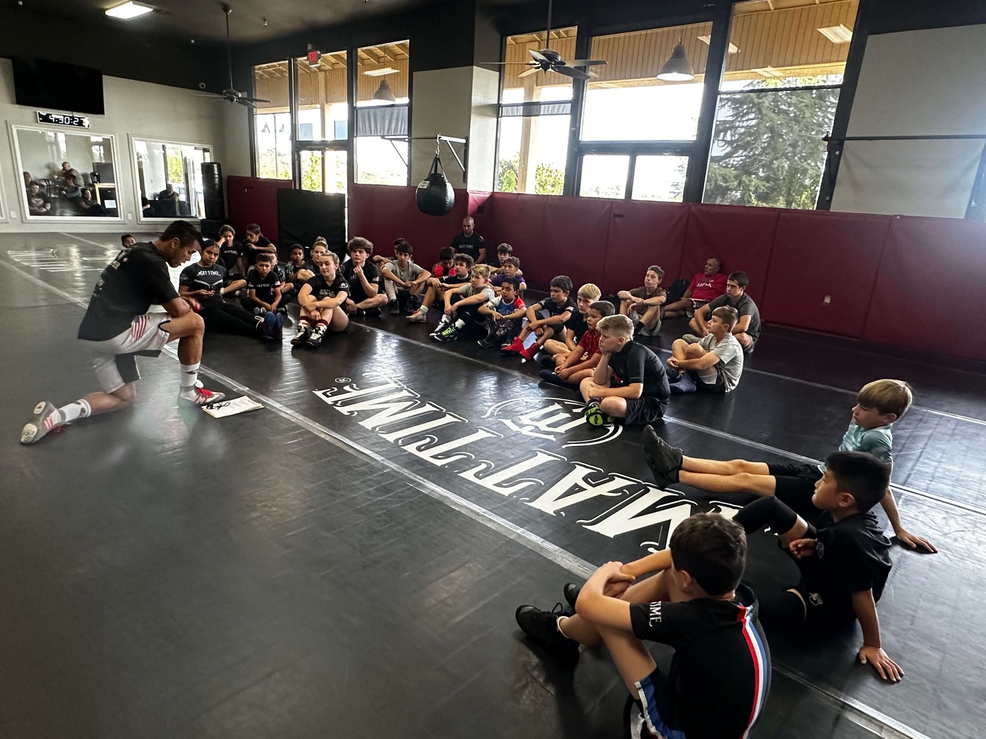 Coach Adrian Garcia teaching a group of MatTime wrestlers