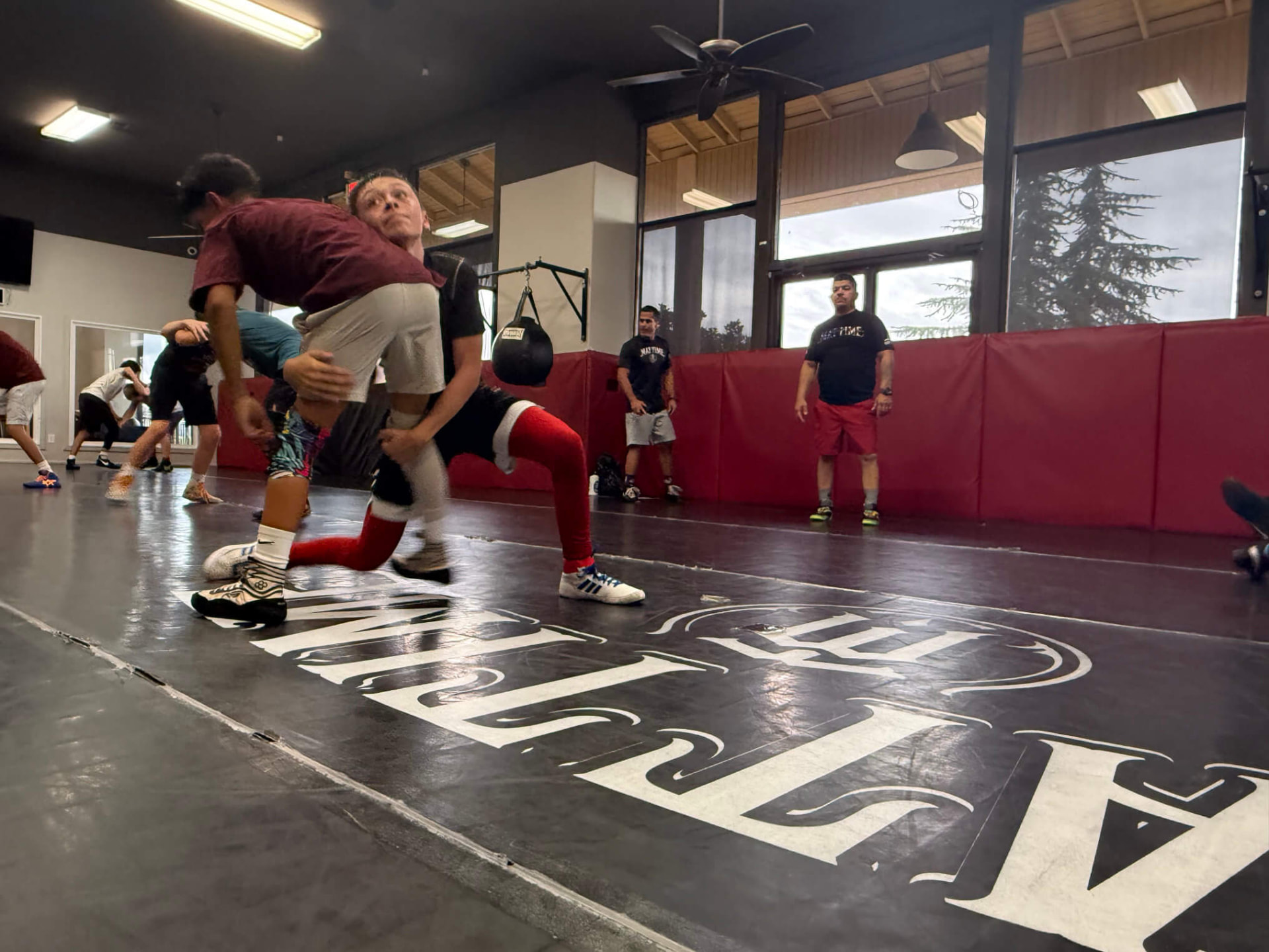 Wrestlers drilling a double-leg takedown at MatTime
